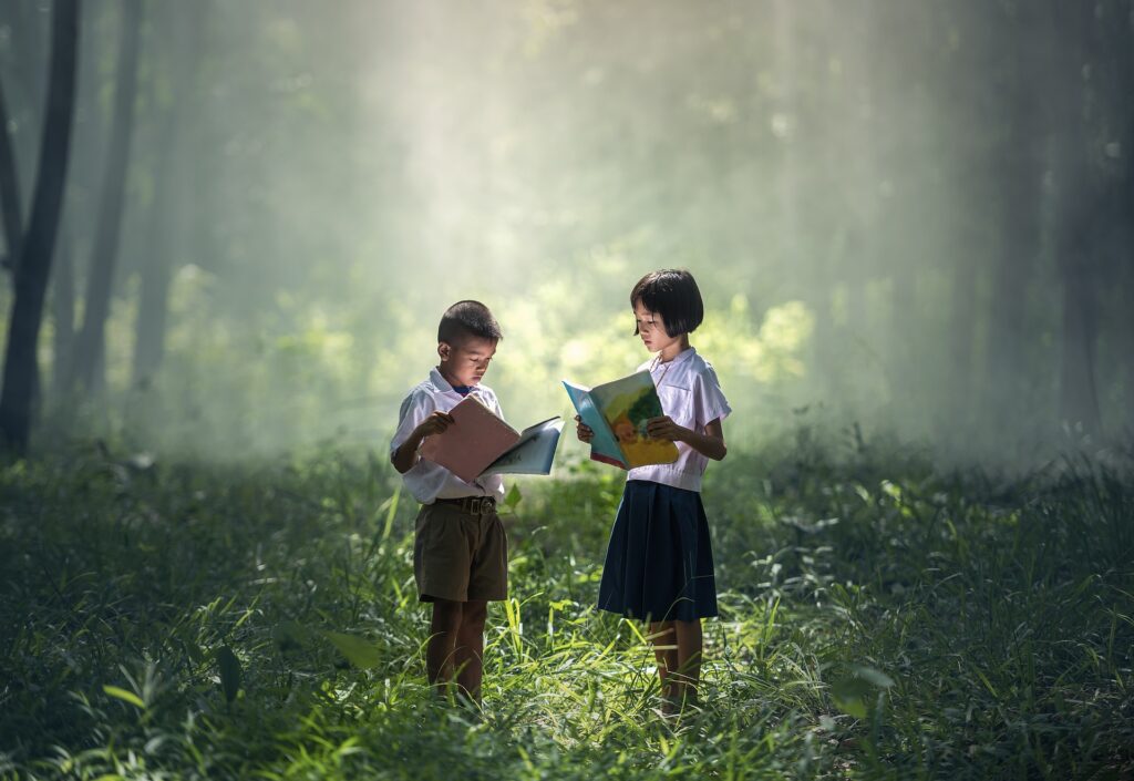 photo of children in the forest, reading books