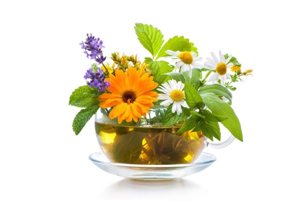 a bouquet of fresh herbs in a glass teacup with saucer.